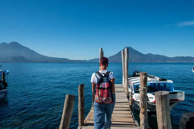 Small group water taxi tour passengers arriving at San Marcos la Laguna pier for swimming at Tzankujil Nature Reserve on Lake Atitlán Guatemala